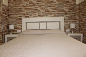 a bedroom with a large bed with two nightstands and two lamps at Estupendo Loft Plaza de Toros in Alicante