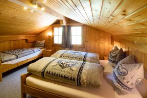 um quarto com duas camas em uma cabana de madeira em Ferienhaus Wisli em Triesenberg