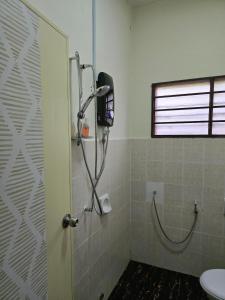 a bathroom with a shower with a toilet and a window at forest villa in Seri Kembangan