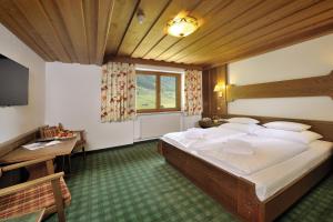 Postel nebo postele na pokoji v ubytování Alpenhotel Tirol