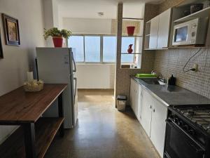 a kitchen with a refrigerator and a table in it at Amplio Departamento 2 dormitorios in Santiago del Estero