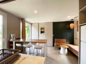 a kitchen and living room with a table and chairs at Camping Canal de Berry in Saint-Amand-Montrond