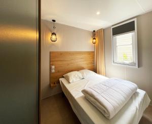 ein Schlafzimmer mit einem Bett mit weißer Bettwäsche und einem Fenster in der Unterkunft Camping Canal de Berry in Saint-Amand-Montrond + 39 Fotos