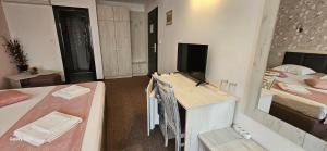 a room with two beds and a desk with a television at Guest House Saint Petka in Veliko Tŭrnovo +59 photos