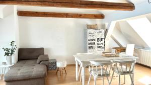 a living room with a white table and chairs at Altstadtloft Straubing in Straubing