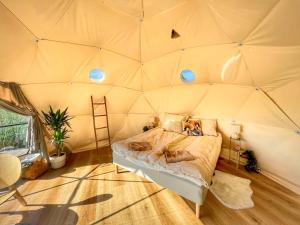 a room with a bed in a tent at Maglebjerggaard Gæstgiveri in Borre