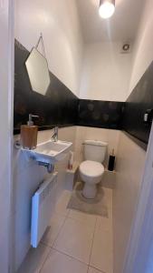 a bathroom with a toilet and a sink at Appartement spacieux à Caen 65 m² avec balcon vue sur la ville in Caen