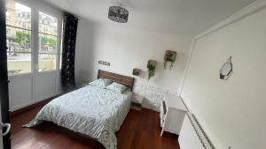 a white bedroom with a bed and a window at Appartement spacieux à Caen 65 m² avec balcon vue sur la ville in Caen