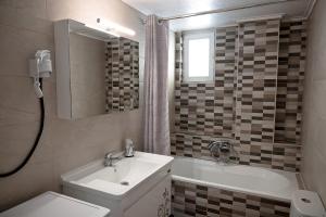 a bathroom with a sink and a tub and a toilet at Efi's apartment in Kalamata +16 photos