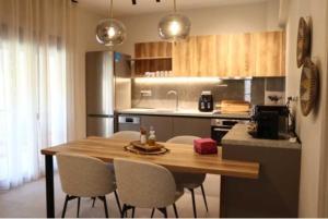 a kitchen with a wooden table and chairs in a kitchen at FILIRA Luxurious Apartment - by Ploumis in Stavros