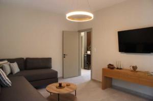 a living room with a couch and a flat screen tv at FILIRA Luxurious Apartment - by Ploumis in Stavros