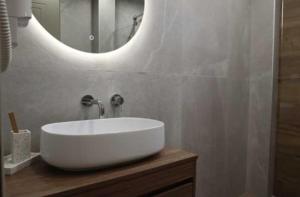 a bathroom with a white sink and a mirror at FILIRA Luxurious Apartment - by Ploumis in Stavros +17 photos