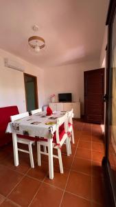 a dining room with a white table and chairs at Il Verde Ulivo in Funtana Meiga
