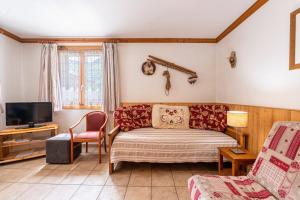 a living room with a bed and a tv at Chalet Le Choucas N°1 in Levassaix