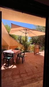 a table and chairs with an umbrella on a patio at Il Verde Ulivo in Funtana Meiga +14 photos