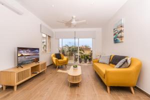 a living room with a yellow couch and a tv at Aparto Almi in Moraira