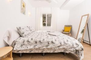 a bedroom with a bed and a chair and a window at Aparto Almi in Moraira