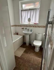 a bathroom with a sink and a toilet and a bath tub at 20mins to BakerSt, Harry Potter & Wembley Stadium! in Northwood