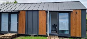 a house with glass doors and a metal roof at Garden House in Pruszcz Gdański