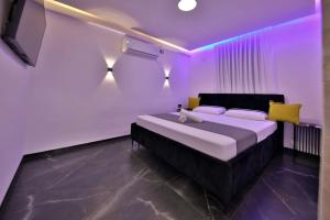 a bedroom with a large bed with purple lighting at שקיעות אדומות in Haifa