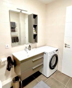 a bathroom with a washing machine and a sink at Nice flat Paris Clichy in Clichy