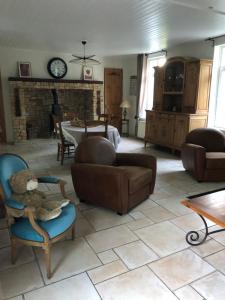 ein Wohnzimmer mit einem Teddybären, der auf einem Stuhl sitzt in der Unterkunft Le clos de la Pommeraie Carly in Carly