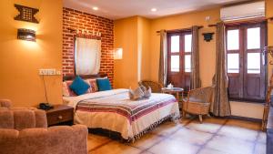 una camera da letto con un letto e un divano in una stanza di Hong Si Hotel- A Home Away from Home a Kathmandu