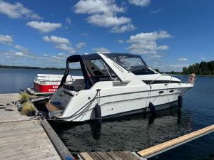 a white boat is docked at a dock at Yachthouse in Plateliai