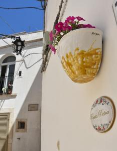 un panier de frites accroché sur le côté d'un bâtiment dans l'établissement Piccola Pietra, à Martina Franca