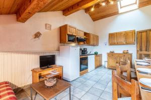 eine Küche mit weißem Kühlschrank und Holzschränken in der Unterkunft Chalet Le Choucas N°3 in Levassaix