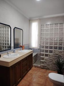 a bathroom with two sinks and a glass wall at Villa Santa Ana in La Carlota
