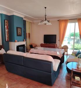 a living room with two beds and a couch at Villa Santa Ana in La Carlota