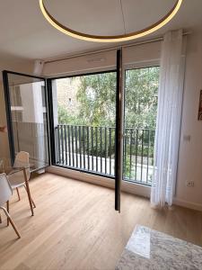 a living room with a large sliding glass door at Nice flat Paris Clichy in Clichy