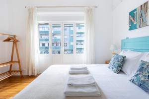 a bedroom with a large white bed with two pillows at Casa da Avenida Lisboa in Lisbon