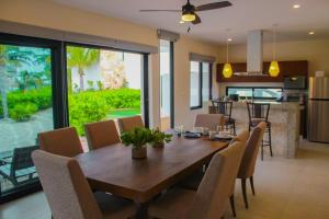 a dining room with a wooden table and chairs at Corcomoran Luxury beachfront house in Telchac Puerto