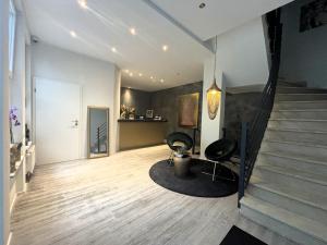 ein Wohnzimmer mit 2 Stühlen und einer Treppe in der Unterkunft Simplex Stays Hotel Quartier 8 in Germersheim