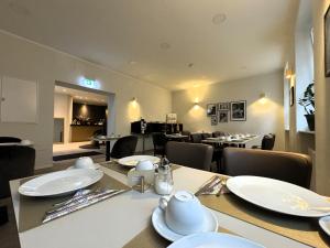 ein Esszimmer mit einem Tisch und weißen Platten darauf in der Unterkunft Simplex Stays Hotel Quartier 8 in Germersheim