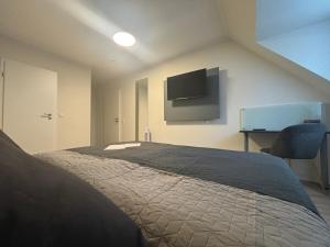 ein Schlafzimmer mit einem Bett und einem Flachbildfernseher in der Unterkunft Boutique Hotel Q8 By Simplex in Germersheim + 35 Fotos