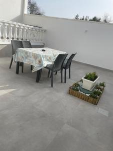 a table and chairs with a table and plants at HOUSE Apartment in Torre Squillace +10 photos