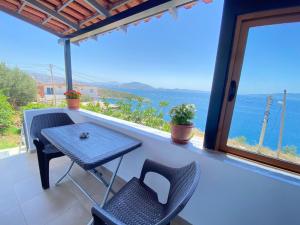 a table and chairs on a balcony with a view of the ocean at Enel Villa in Sarandë
