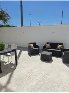 a patio with couches and a table and a table and chairs at HOUSE Apartment in Torre Squillace