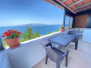 a table and chairs on a balcony with a view of the ocean at Enel Villa in Sarandë