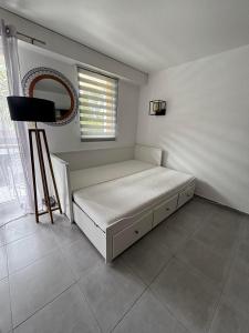 a white bedroom with a bed and a mirror at Appartement studio 4 personnes dans résidence proche centre in Quiberon +10 photos
