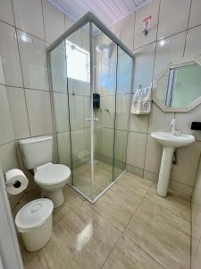 a bathroom with a shower and a toilet and a sink at Suítes e PENHA-SC in Penha +16 photos
