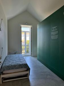 a bedroom with a bed with a green wall at Surf & Sea Suites in Parede