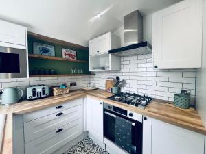 a kitchen with white cabinets and a stove top oven at 7a Seatreat in Kinghorn