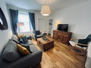 a living room with a couch and a tv at 7a Seatreat in Kinghorn