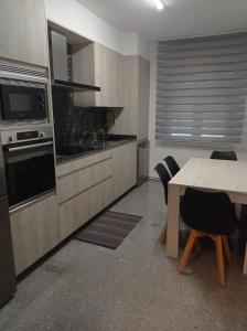 a kitchen with a table and some chairs and a counter at Adro Vello in San Vicente de O Grove