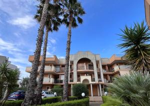 a building with palm trees in front of it at Little House in Lecce