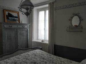 a bedroom with a bed and a window and a mirror at Chez Marie in Cancale